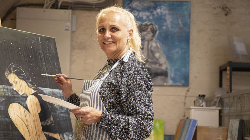 Kunstner Guro Bergli i arbeid med et maleri i atelieret sitt i Gamlebyen.