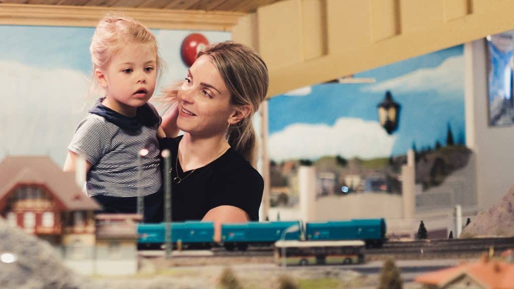 Mor og barn ser på tog i Gamlebyen Modelljernbanesenter.