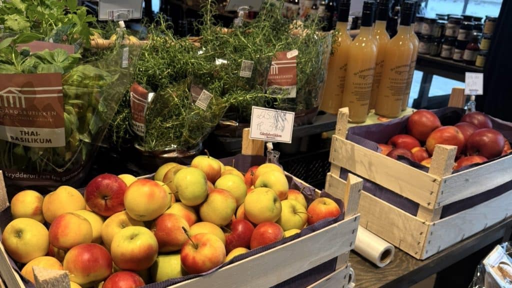 Kasser med epler, nektariner og ferske urter i gårdsbutikken i Matværste.