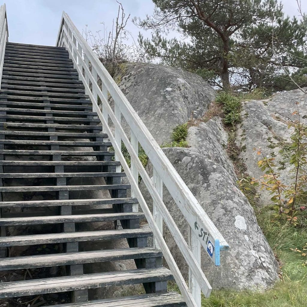 Tretrapp med blått kyststimerke, ved starten på Kjærlighetsstien.
